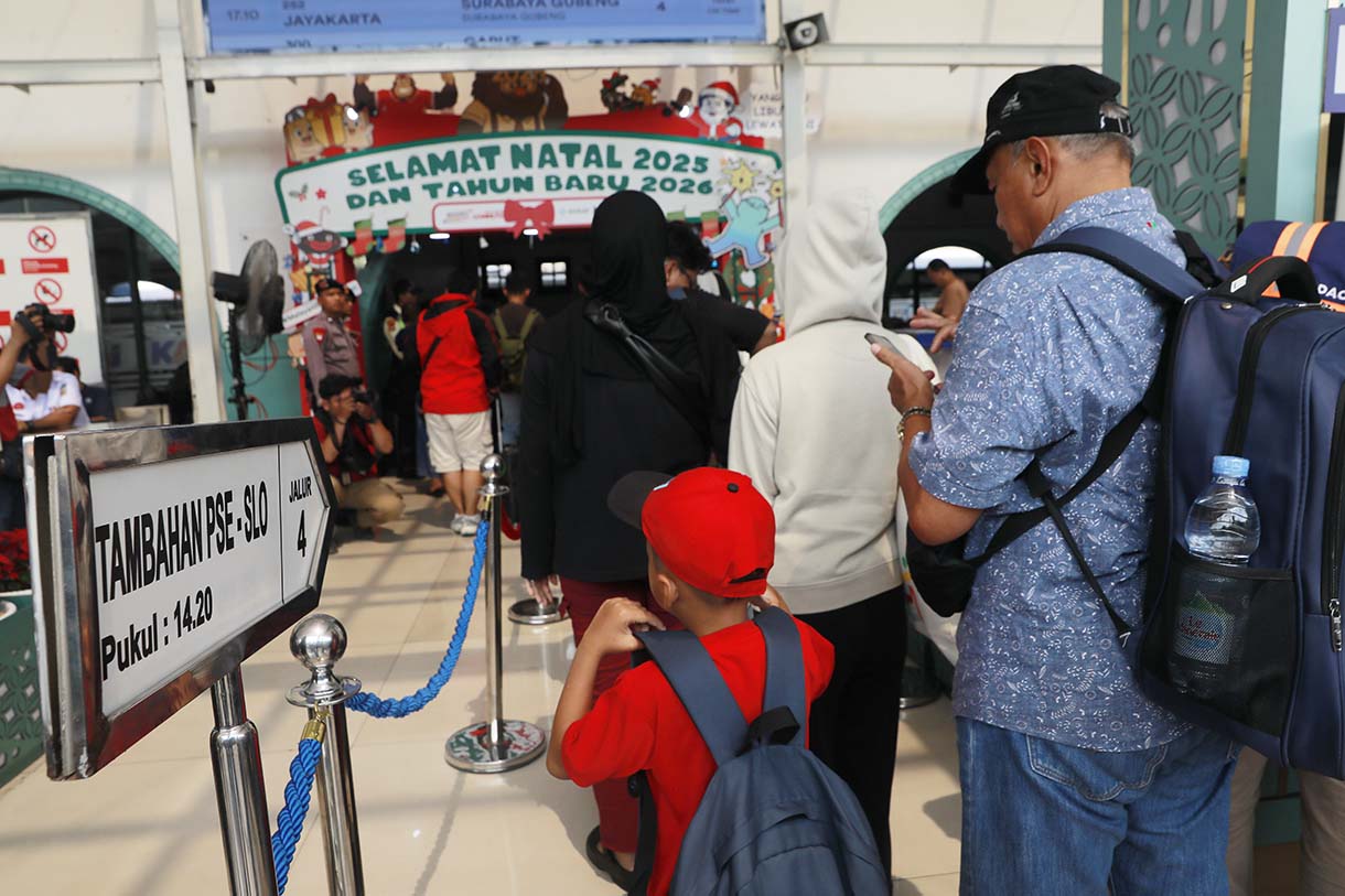 Sejumlah calon penumpang kereta mengantre untuk memasuki peron di Stasiun Pasar Senen, Jakarta, Selasa (23/12/2025).  (Beritanasional.com/Oke Atmaja)