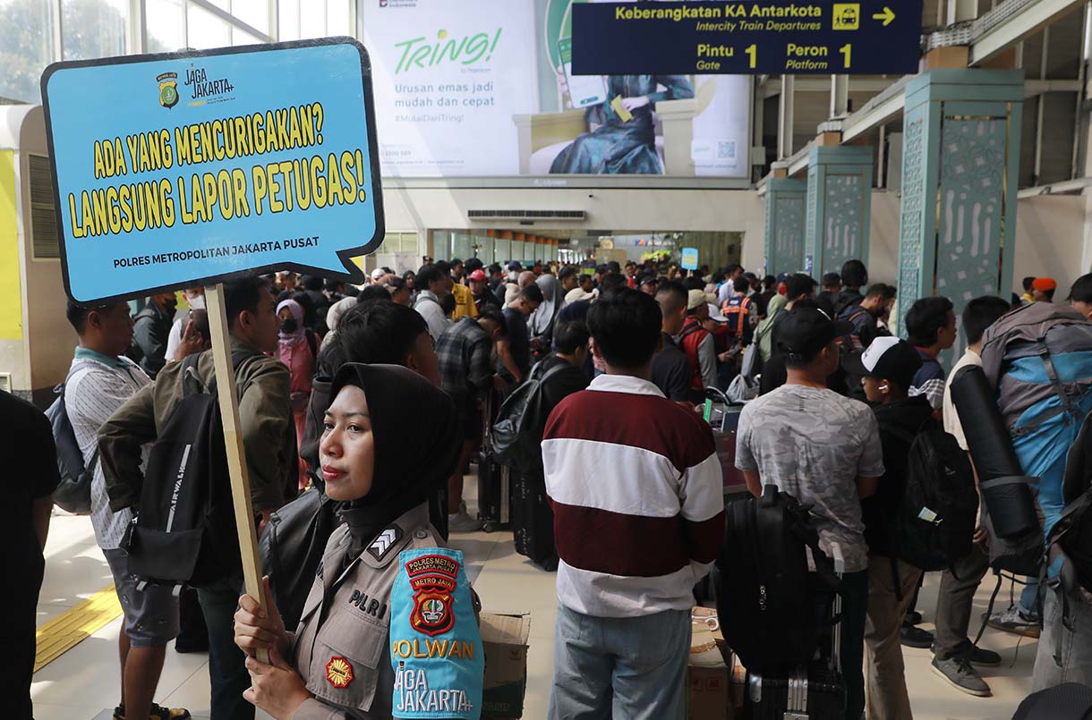 Sejumlah calon penumpang kereta mengantre untuk memasuki peron di Stasiun Pasar Senen, Jakarta, Selasa (23/12/2025).  (Beritanasional.com/Oke Atmaja)
