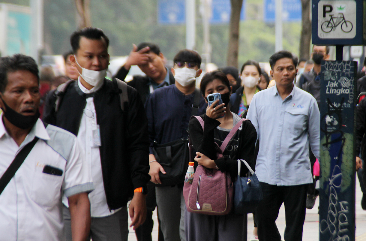 Pekerja berjalan saat jam berangkat kerja di kawasan Jalan Jenderal Sudirman, Jakarta, Rabu (7/8/2024).  (BeritaNasional.com/Oke Atmaja)