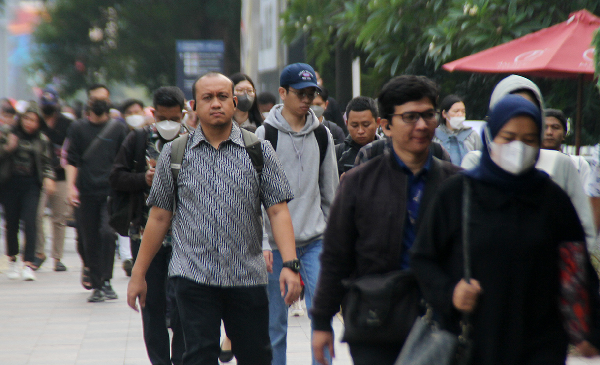 Pekerja berjalan saat jam berangkat kerja di kawasan Jalan Jenderal Sudirman, Jakarta, Rabu (7/8/2024).  (BeritaNasional.com/Oke Atmaja)