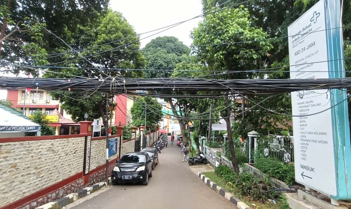 Kabel Semrawut di Tebet Warga melintas di samping kabel utilitas yang semrawut dikawasan Tebet, Jakarta, Jumat (31/10/2025).   (Beritanasional.com/Oke Atmaja)