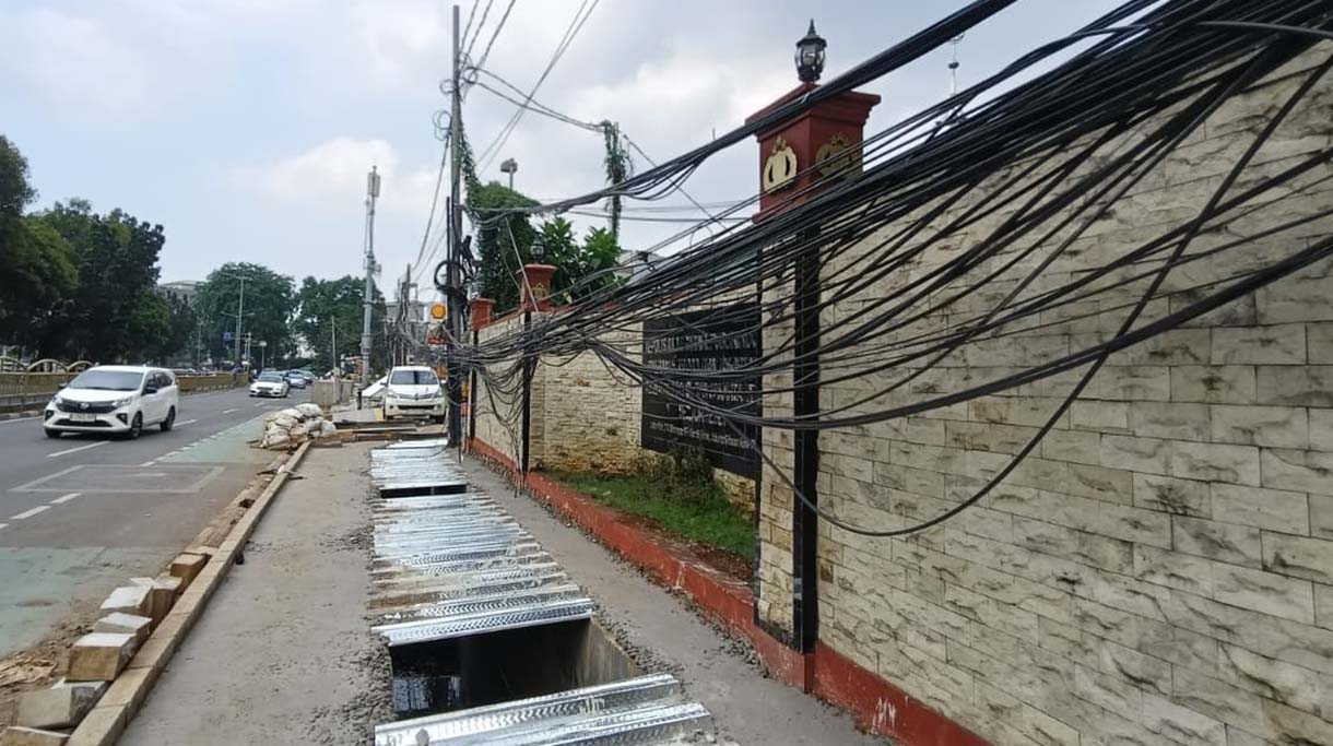 Kabel Semrawut di Tebet Warga melintas di samping kabel utilitas yang semrawut dikawasan Tebet, Jakarta, Jumat (31/10/2025).   (Beritanasional.com/Oke Atmaja)