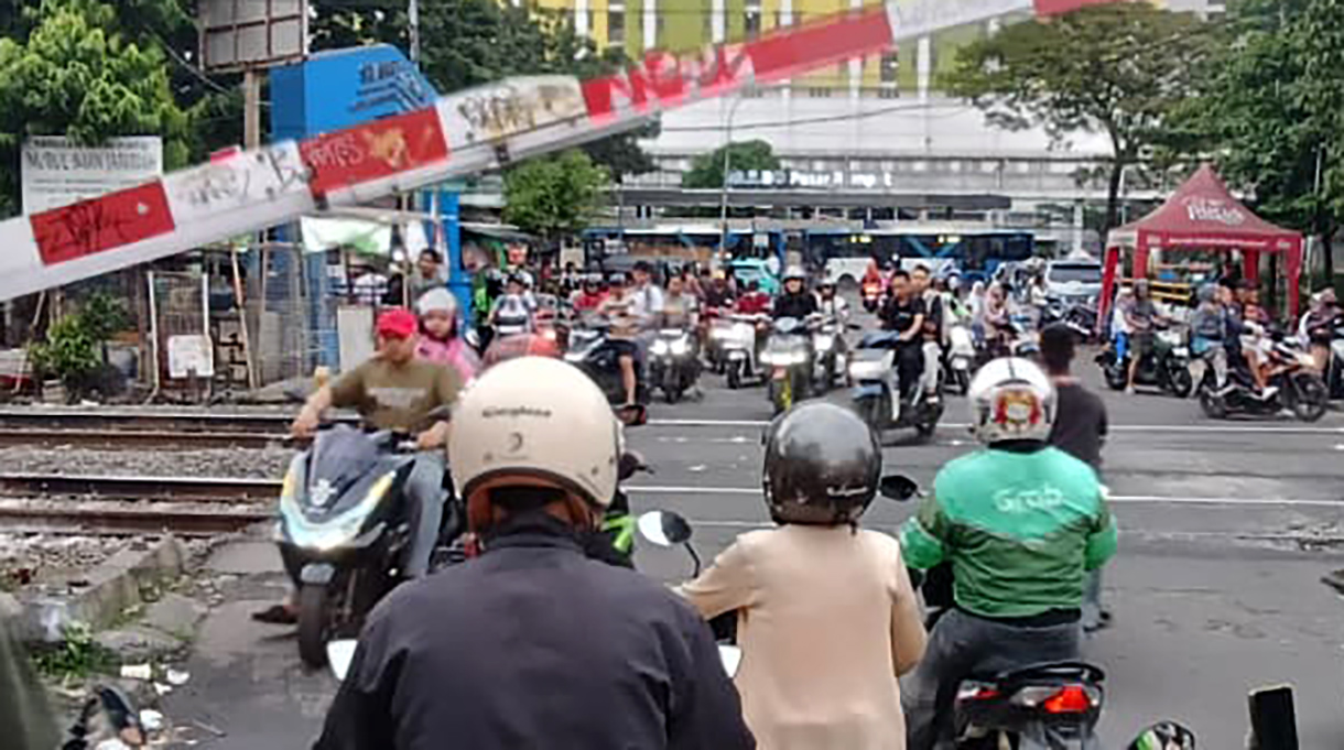 Sejumlah pengendara motor menunggu untuk menyeberangi jalur perlintasan kereta sebidang di kawasan Menteng,Jakarta, Senin (4/5/2026).  (Beritanasional.com/Oke Atmaja)