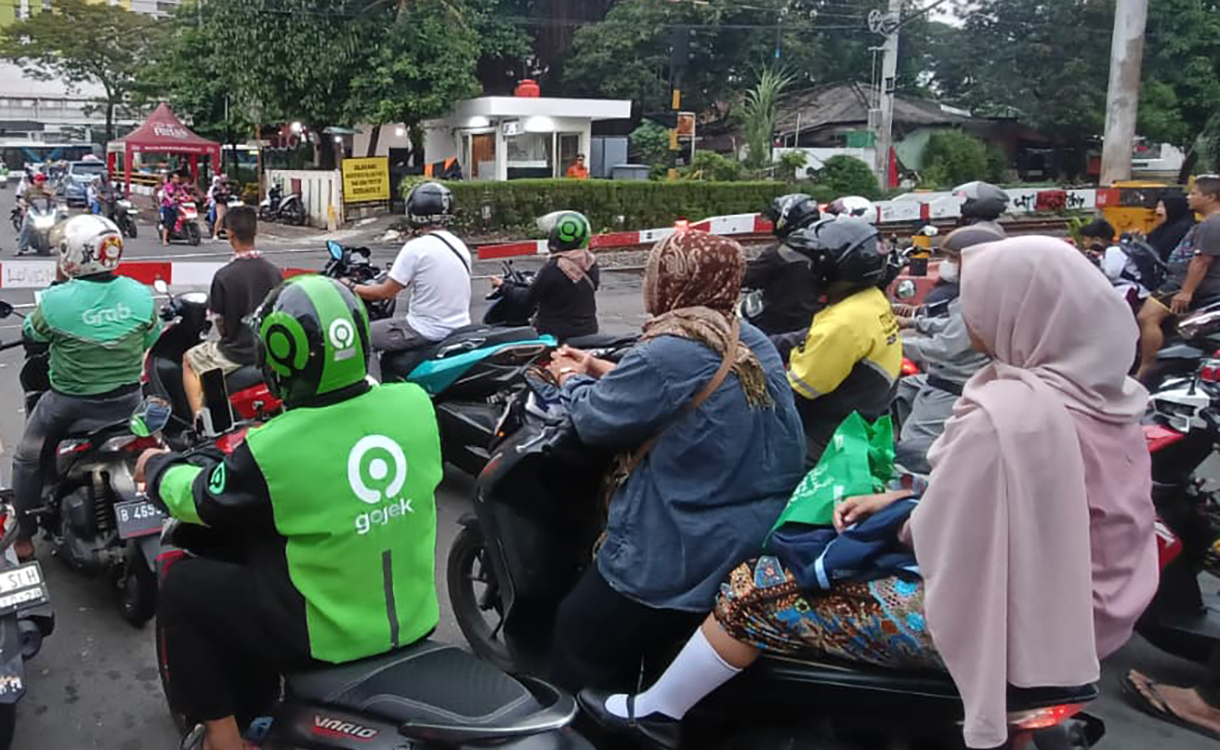 Sejumlah pengendara motor menunggu untuk menyeberangi jalur perlintasan kereta sebidang di kawasan Menteng,Jakarta, Senin (4/5/2026).  (Beritanasional.com/Oke Atmaja)