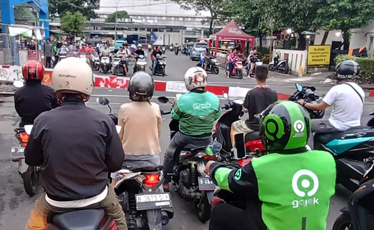 Sejumlah pengendara motor menunggu untuk menyeberangi jalur perlintasan kereta sebidang di kawasan Menteng,Jakarta, Senin (4/5/2026).  (Beritanasional.com/Oke Atmaja)