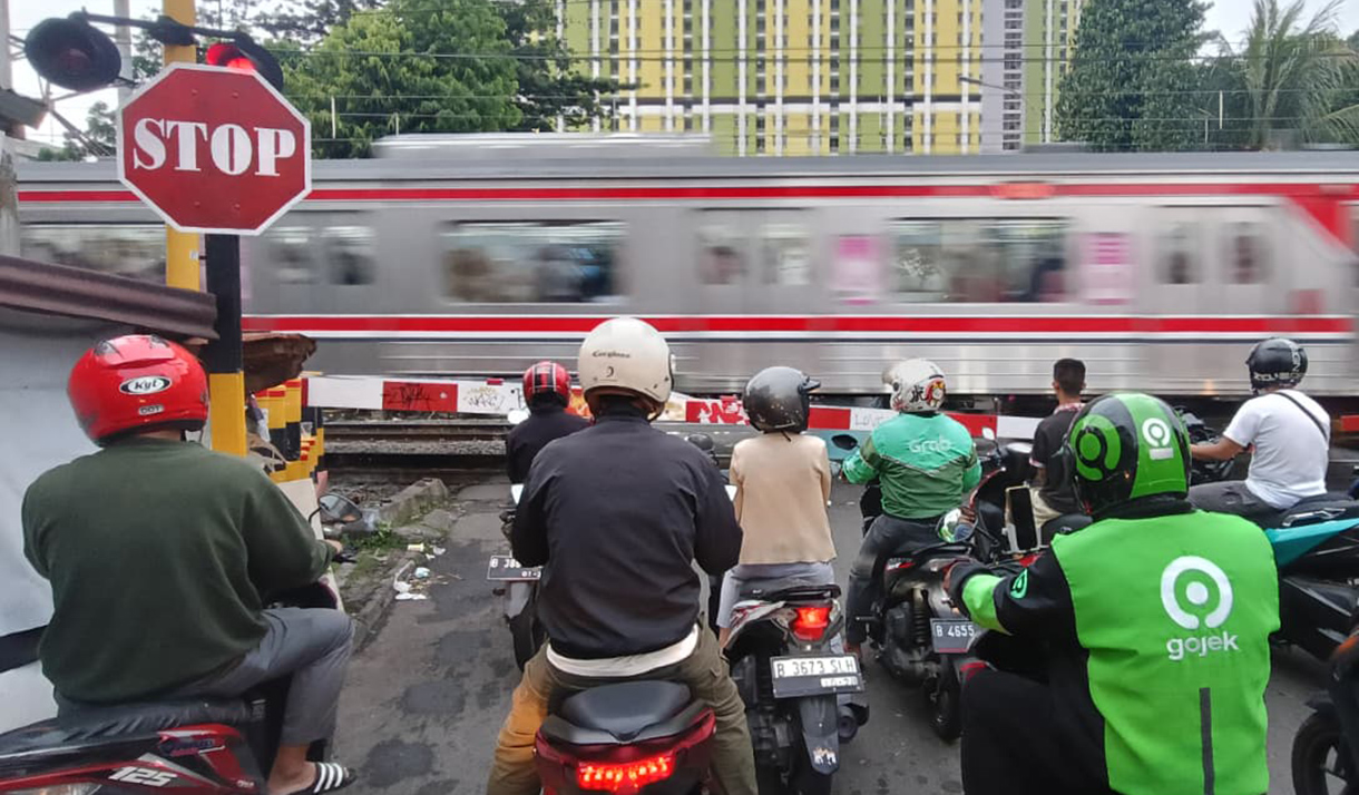 Sejumlah pengendara motor menunggu untuk menyeberangi jalur perlintasan kereta sebidang di kawasan Menteng,Jakarta, Senin (4/5/2026).  (Beritanasional.com/Oke Atmaja)