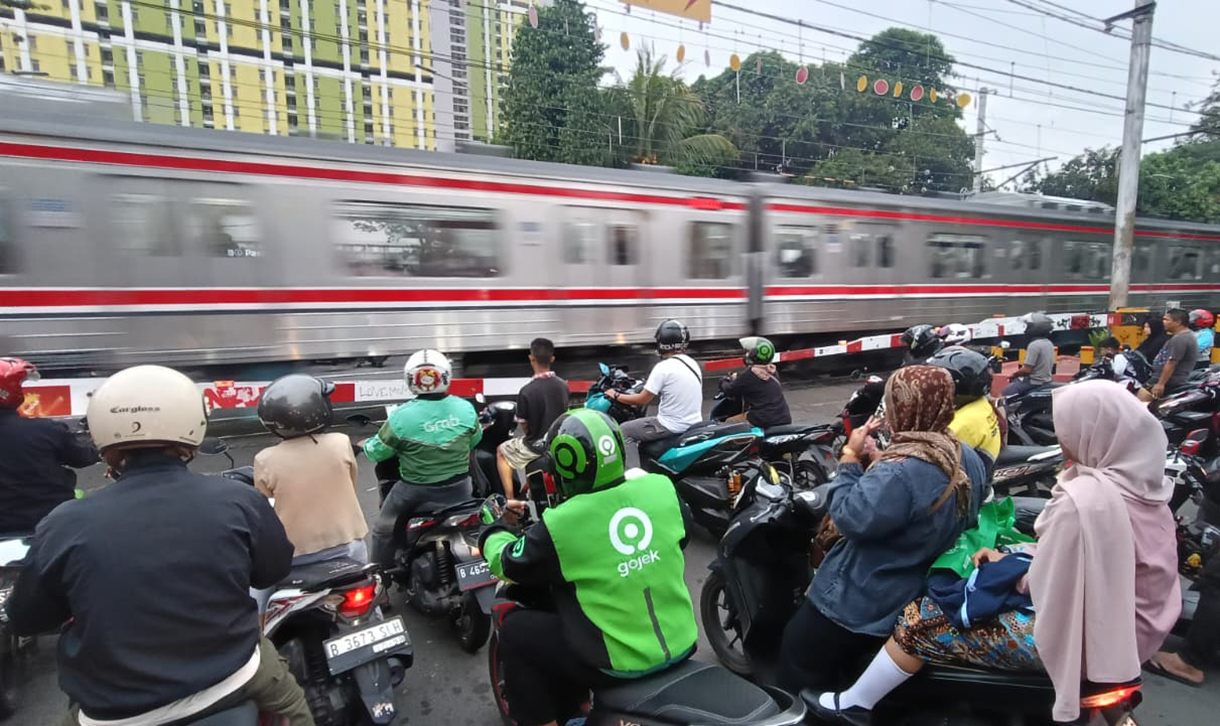 Sejumlah pengendara motor menunggu untuk menyeberangi jalur perlintasan kereta sebidang di kawasan Menteng,Jakarta, Senin (4/5/2026).  (Beritanasional.com/Oke Atmaja)