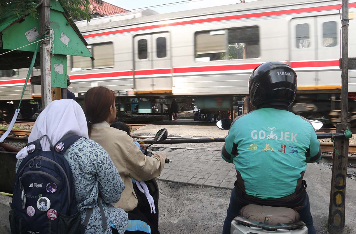 Warga dan pengendara motor melintasi perlintasan sebidang di kawasan Tebet Timur, Jakarta, Selasa (19/5/2026).  (Beritanasional.com/Oke Atmaja)