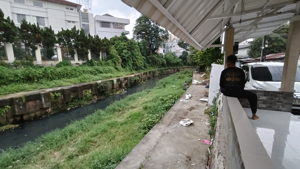 Seorang warga beraktivitas di bantaran Kali Ciliwung kawasan Matraman, Jakarta Timur, Selasa (14/4/2026). (Beritanasional.com/Oke Atmaja).