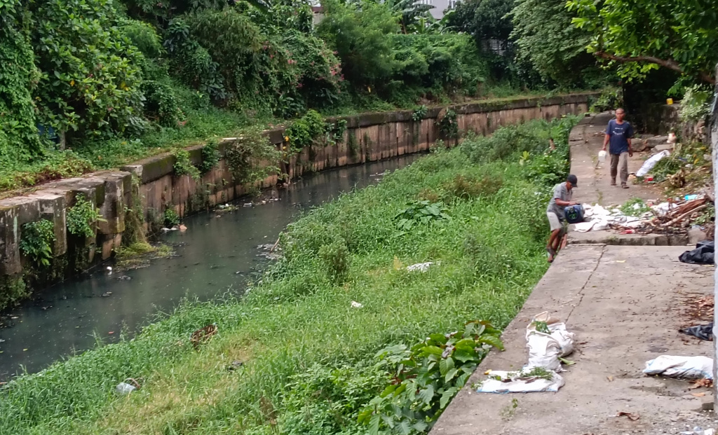 Seorang warga beraktivitas di bantaran Kali Ciliwung kawasan Matraman, Jakarta Timur, Selasa (14/4/2026). (Beritanasional.com/Oke Atmaja).
