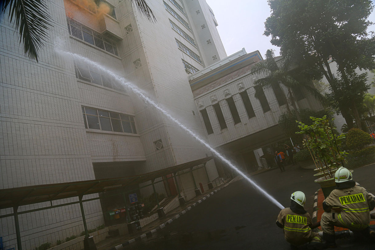 Pekerja berlindung di bawah meja dalam simulasi penanganan gempa dan kebakaran di Kantor Wali Kota Administrasi Jakarta Utara, Jakarta, Rabu (2/10/2024).  (BeritaNasional.com/Oke Atmaja)