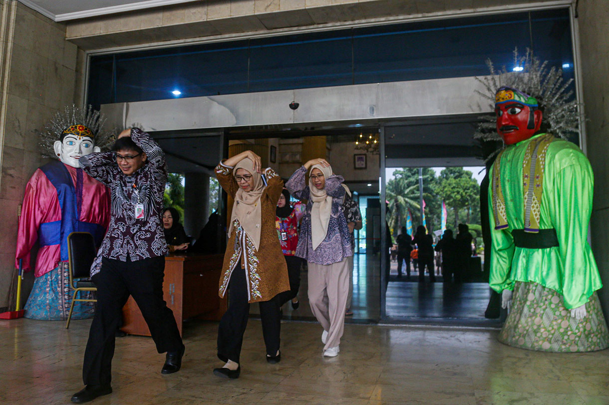 Pekerja berlindung di bawah meja dalam simulasi penanganan gempa dan kebakaran di Kantor Wali Kota Administrasi Jakarta Utara, Jakarta, Rabu (2/10/2024).  (BeritaNasional.com/Oke Atmaja)