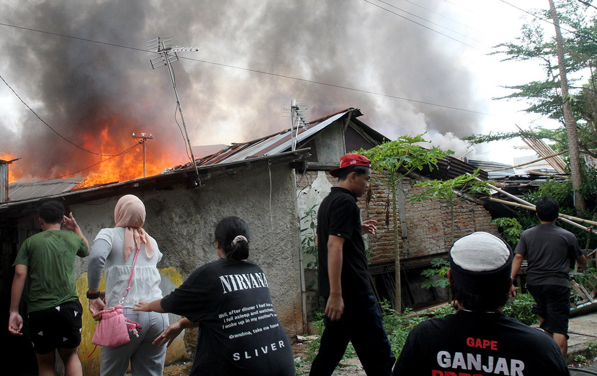 Warga berusaha memadamkan api yang membakar permukiman padat di Kawasan Menteng, Jakarta Pusat, Jumat (20/12/2024).(BeritaNasional.com/Oke Atmaja)