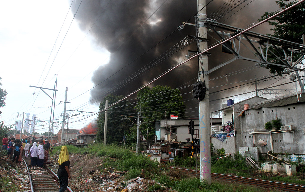 Warga berusaha memadamkan api yang membakar permukiman padat di Kawasan Menteng, Jakarta Pusat, Jumat (20/12/2024).(BeritaNasional.com/Oke Atmaja)