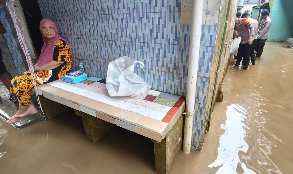 Kebon Pala Jaktim Masih Terendam Banjir Warga melintasi banjir di Kebon Pala, Jatinegara, Jakarta Timur, Senin (7/7/2025). (Beritanasional.com/Oke Atmaja)
