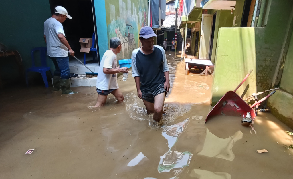 Kebon Pala Jaktim Masih Terendam Banjir Warga melintasi banjir di Kebon Pala, Jatinegara, Jakarta Timur, Senin (7/7/2025). (Beritanasional.com/Oke Atmaja)