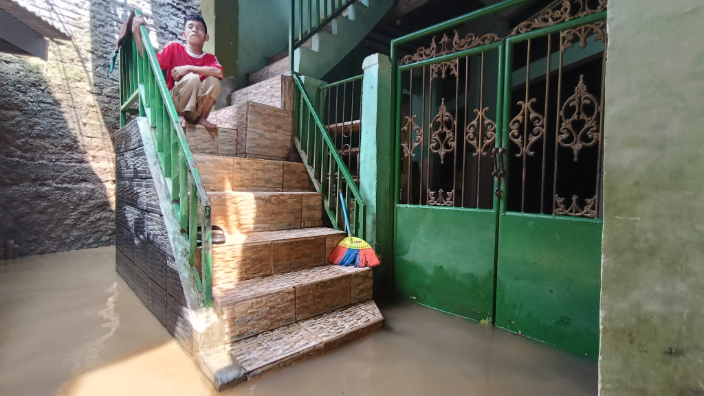 Kebon Pala Jaktim Masih Terendam Banjir Warga melintasi banjir di Kebon Pala, Jatinegara, Jakarta Timur, Senin (7/7/2025). (Beritanasional.com/Oke Atmaja)
