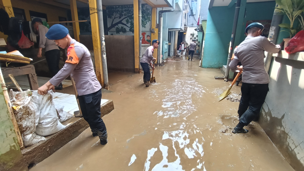 Warga melintasi banjir di Kebon Pala, Jatinegara, Jakarta Timur, Senin (7/7/2025).  (Beritanasional.com/Oke Atmaja)