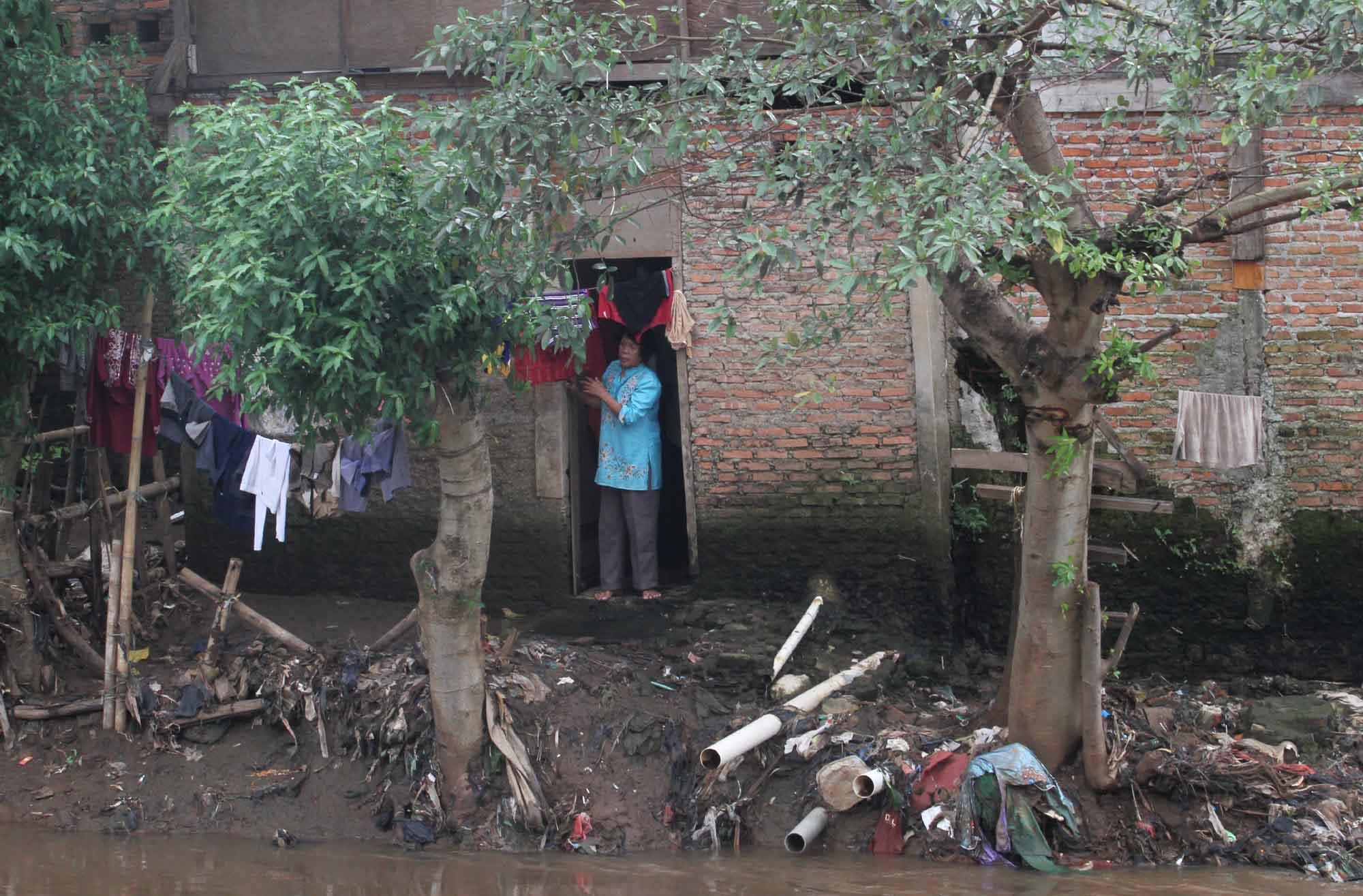 Warga mengambil air di aliran Sungai Ciliwung, Manggarai, Jakarta, Selasa (30/7/2024).(BeritaNasional.com/Oke Atmaja)