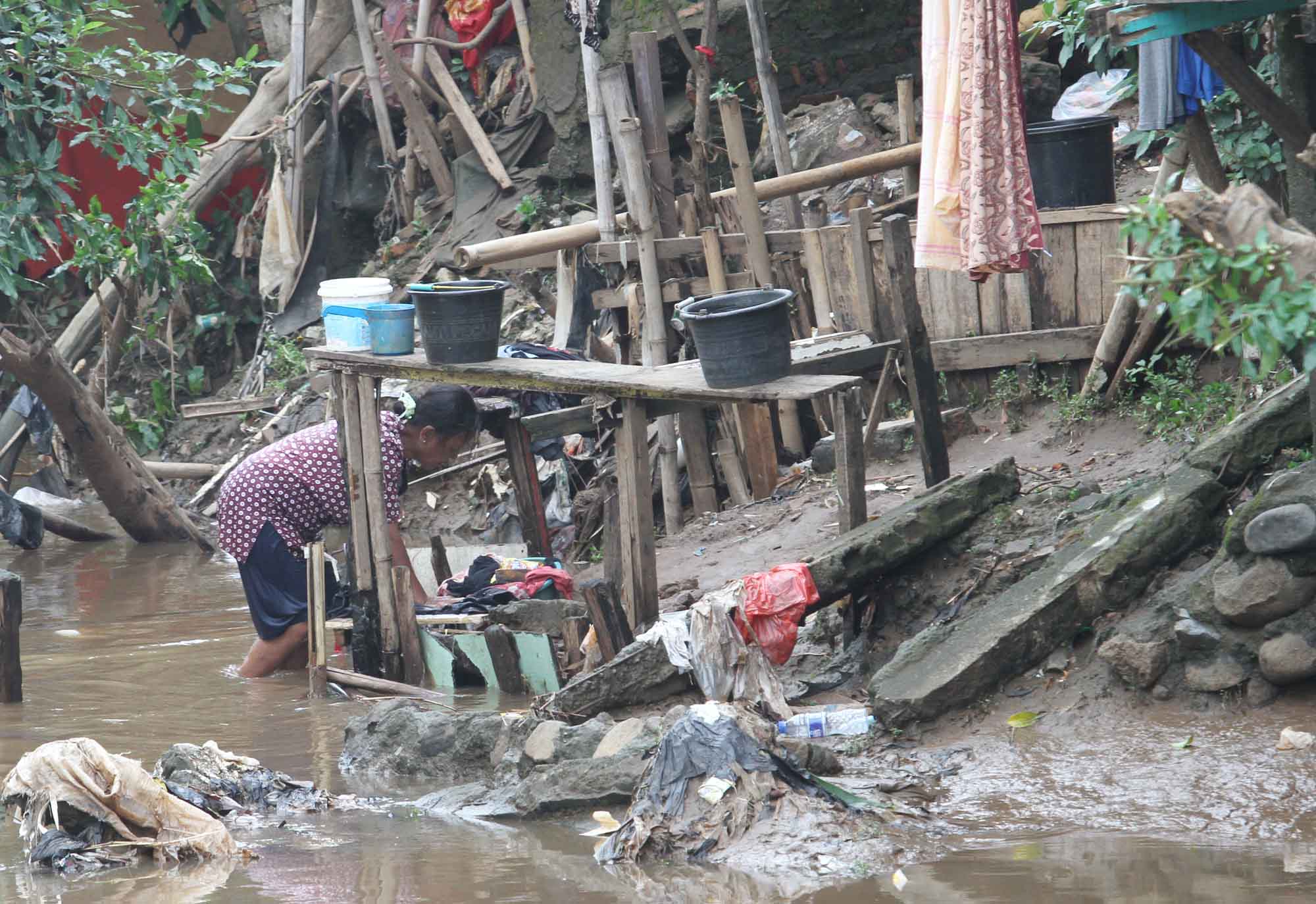 Warga mengambil air di aliran Sungai Ciliwung, Manggarai, Jakarta, Selasa (30/7/2024).(BeritaNasional.com/Oke Atmaja)