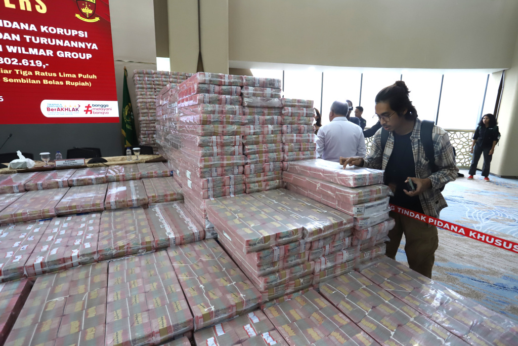 Kejagung Sita 11 triliun Lebih Terkait korupsi Ekspor CPO Petugas merapikan barang bukti uang sitaan saat konferensi pers kasus korupsi ekspor crude palm oil (CPO) di Gedung Bundar Jampidus Kejaksaaan Agung (Kejagung), Jakarta, Selasa (17/6/2025). (Beritanasional.com/Oke Atmaja)