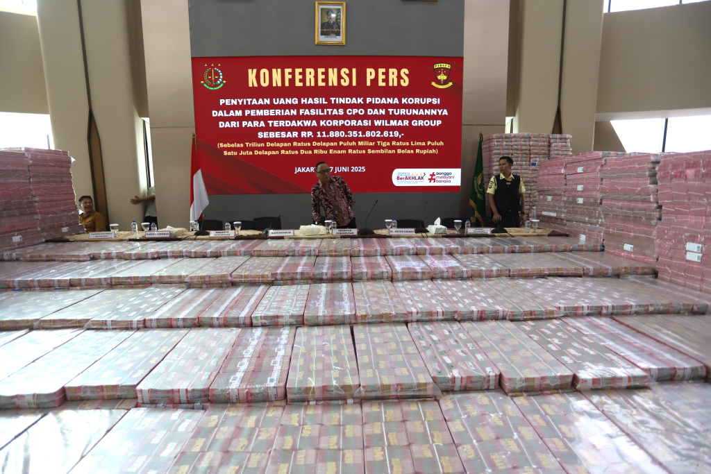Kejagung Sita 11 triliun Lebih Terkait korupsi Ekspor CPO Petugas merapikan barang bukti uang sitaan saat konferensi pers kasus korupsi ekspor crude palm oil (CPO) di Gedung Bundar Jampidus Kejaksaaan Agung (Kejagung), Jakarta, Selasa (17/6/2025). (Beritanasional.com/Oke Atmaja)