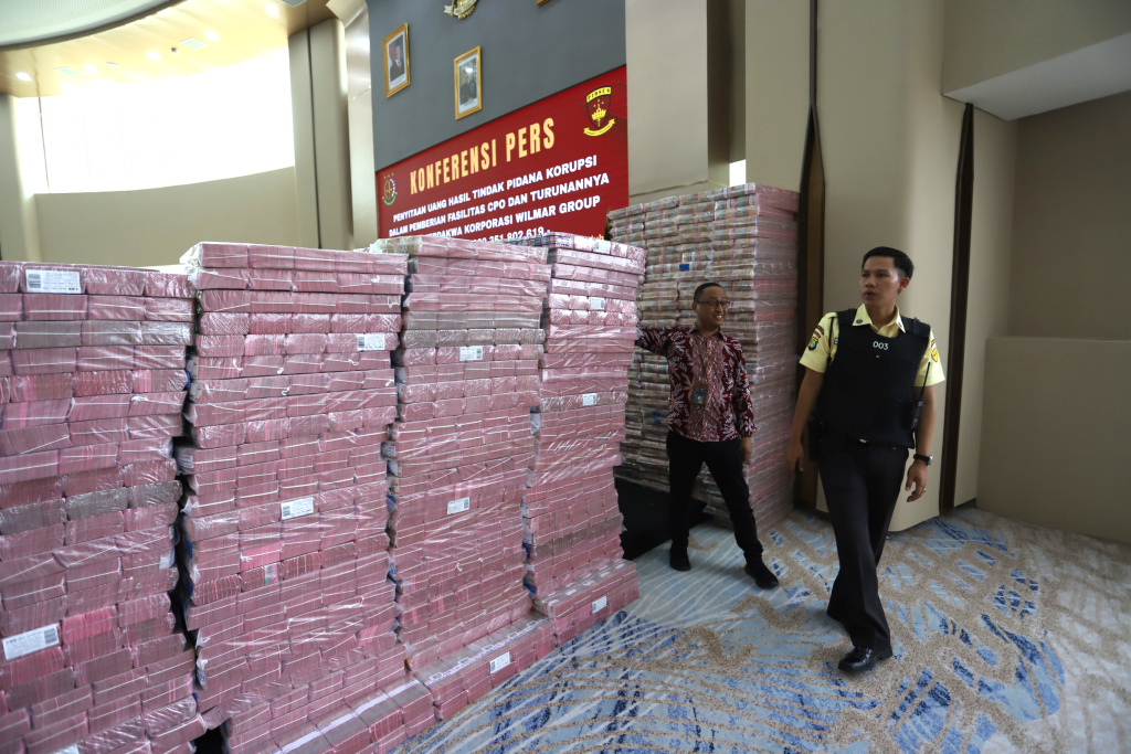 Kejagung Sita 11 triliun Lebih Terkait korupsi Ekspor CPO Petugas merapikan barang bukti uang sitaan saat konferensi pers kasus korupsi ekspor crude palm oil (CPO) di Gedung Bundar Jampidus Kejaksaaan Agung (Kejagung), Jakarta, Selasa (17/6/2025). (Beritanasional.com/Oke Atmaja)