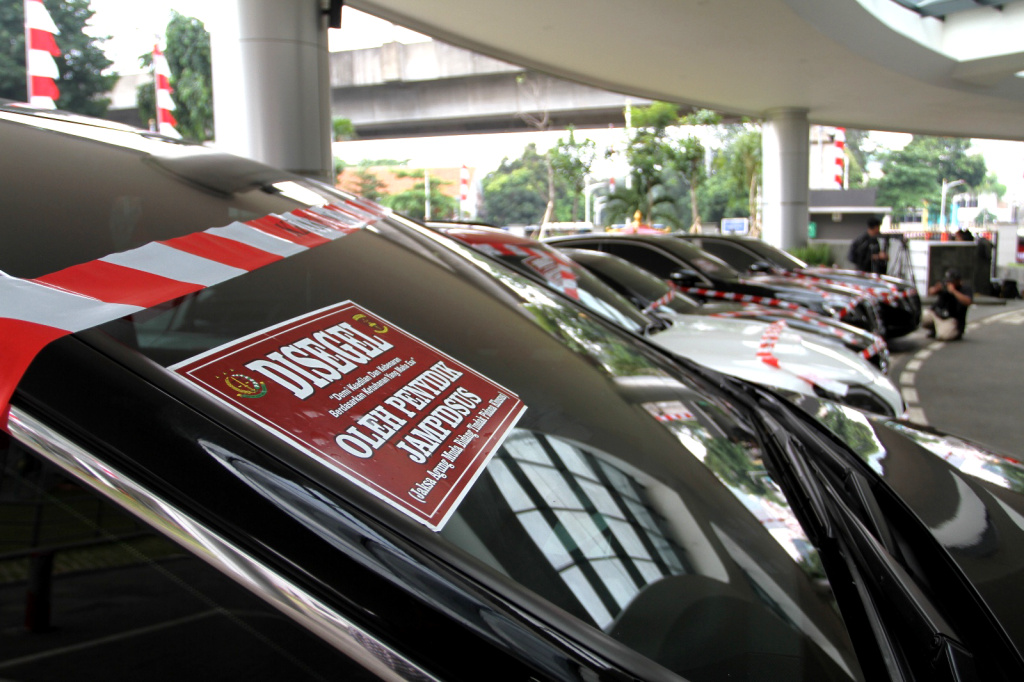 Kejagung Sita Mobil Mewah Diduga Milik Riza Chalid Warga melintas di depan sejumlah mobil sitaan penyidik Jaksa Agung Muda Bidang Tindak Pidana Khusus (Jampidsus) di Kejaksaan Agung, Jakarta, Selasa (5/8/2025). (Beritanasional.com/Oke Atmaja)