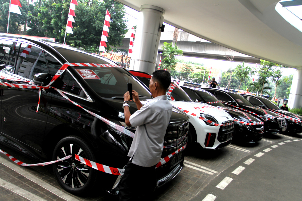 Kejagung Sita Mobil Mewah Diduga Milik Riza Chalid Warga melintas di depan sejumlah mobil sitaan penyidik Jaksa Agung Muda Bidang Tindak Pidana Khusus (Jampidsus) di Kejaksaan Agung, Jakarta, Selasa (5/8/2025). (Beritanasional.com/Oke Atmaja)