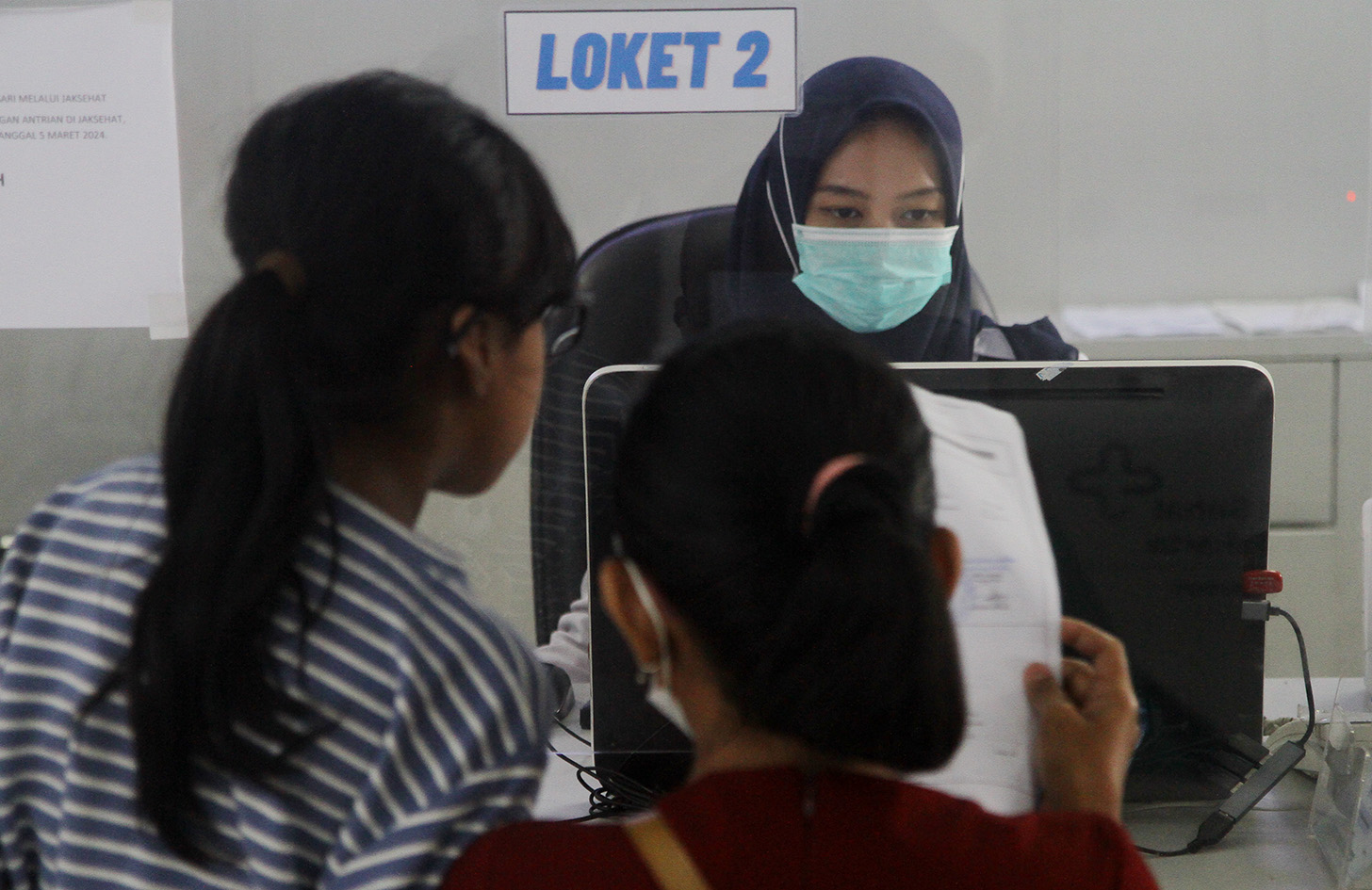 Petugas melayani pendaftaran pengguna BPJS Kesehatan di RSUD Taman Sari, Jakarta, Kamis (18/4/2024).(BeritaNasional.com/Oke Atmaja)
