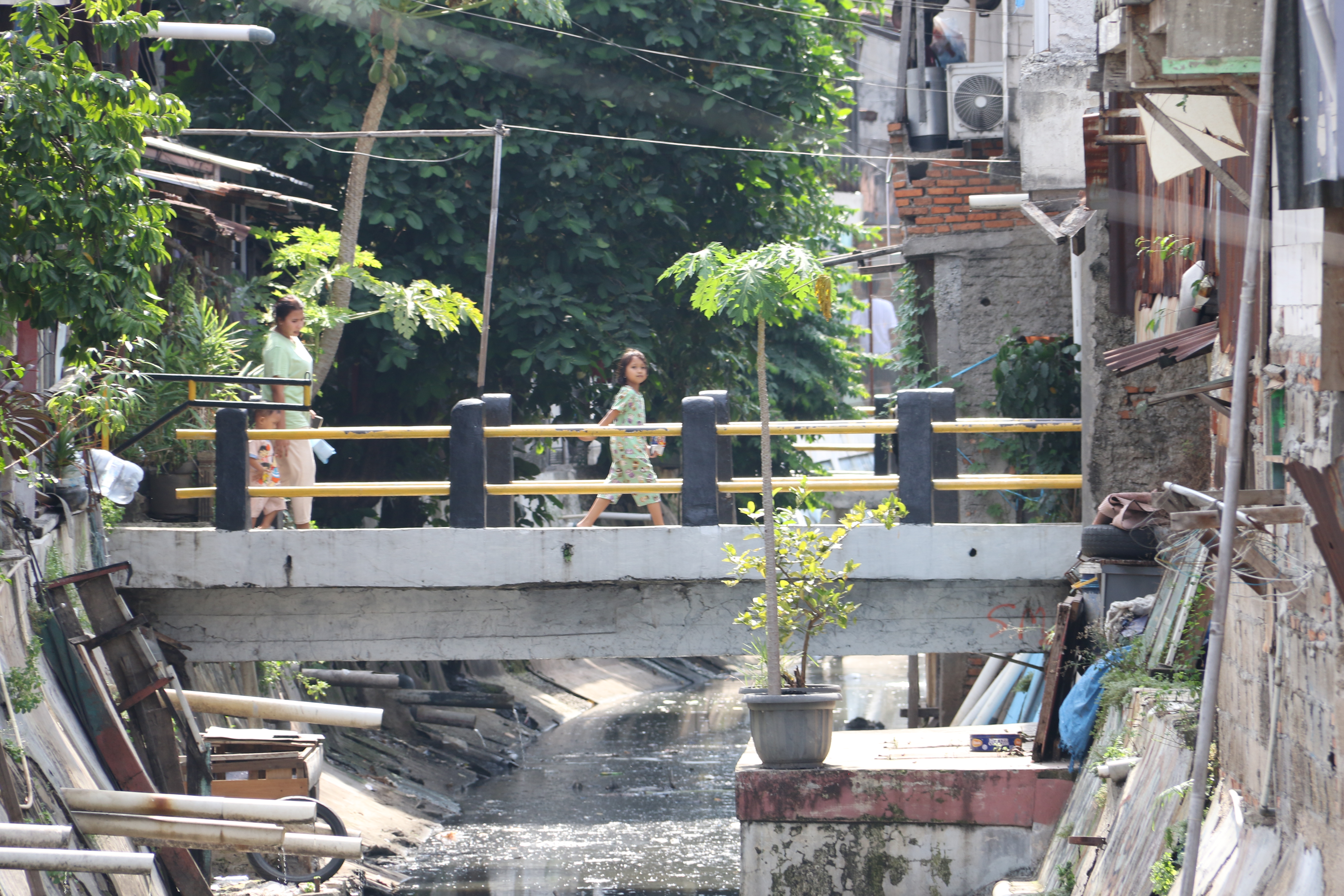 Warga melintas di jembatan kali ciliwung, Menteng, Jakarta, Rabu (10/9/2025).  (Beritanasional.com/Oke Atmaja)