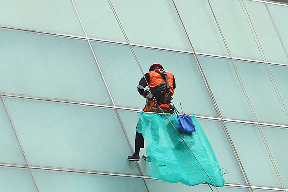 Kemnaker Perluas Cakupan Perlindungan Kerja Pekerja membersihkan kaca dinding west mall Kempinski, Jakarta. (BeritaNasional/Elvis Sendouw)