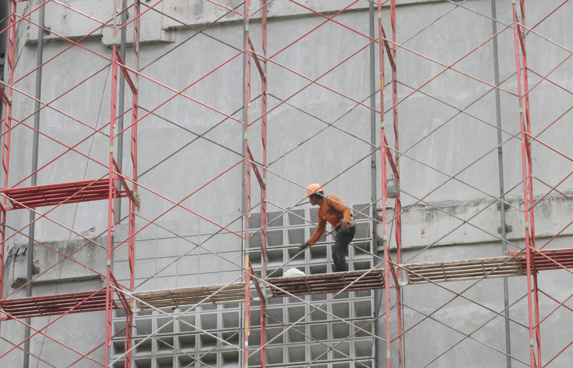 Pekerja mengerjakan pemasangan esi proyek pembangunan Gedung, di Kawasan Kota Tua, Jakarta, Rabu (01/01/2024).  (BeritaNasional.com/Oke Atmaja)