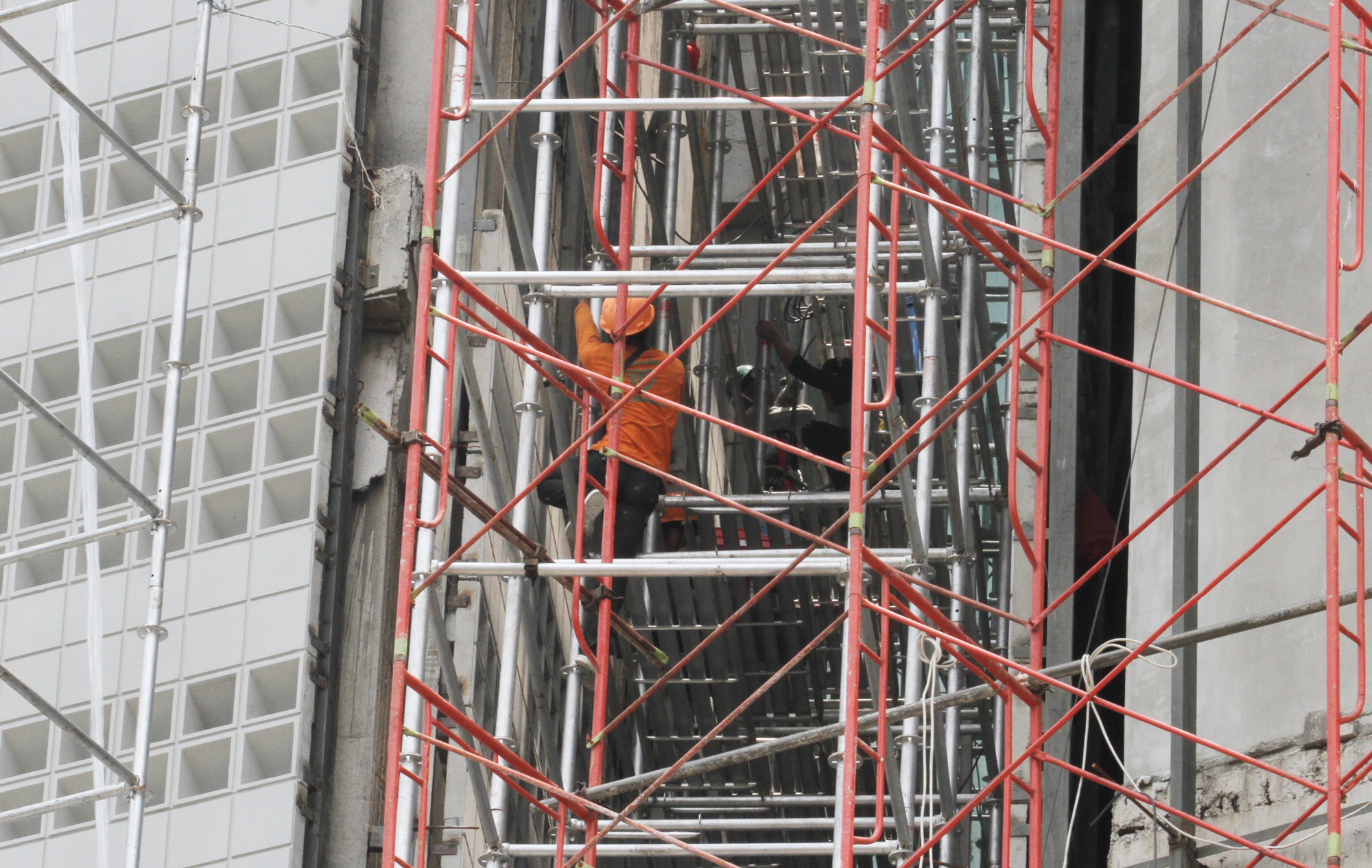 Pekerja mengerjakan pemasangan esi proyek pembangunan Gedung, di Kawasan Kota Tua, Jakarta, Rabu (01/01/2024).  (BeritaNasional.com/Oke Atmaja)