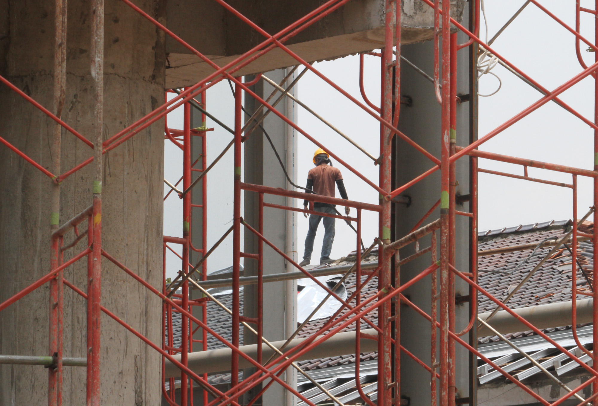 Pekerja mengerjakan pemasangan esi proyek pembangunan Gedung, di Kawasan Kota Tua, Jakarta, Rabu (01/01/2024).  (BeritaNasional.com/Oke Atmaja)