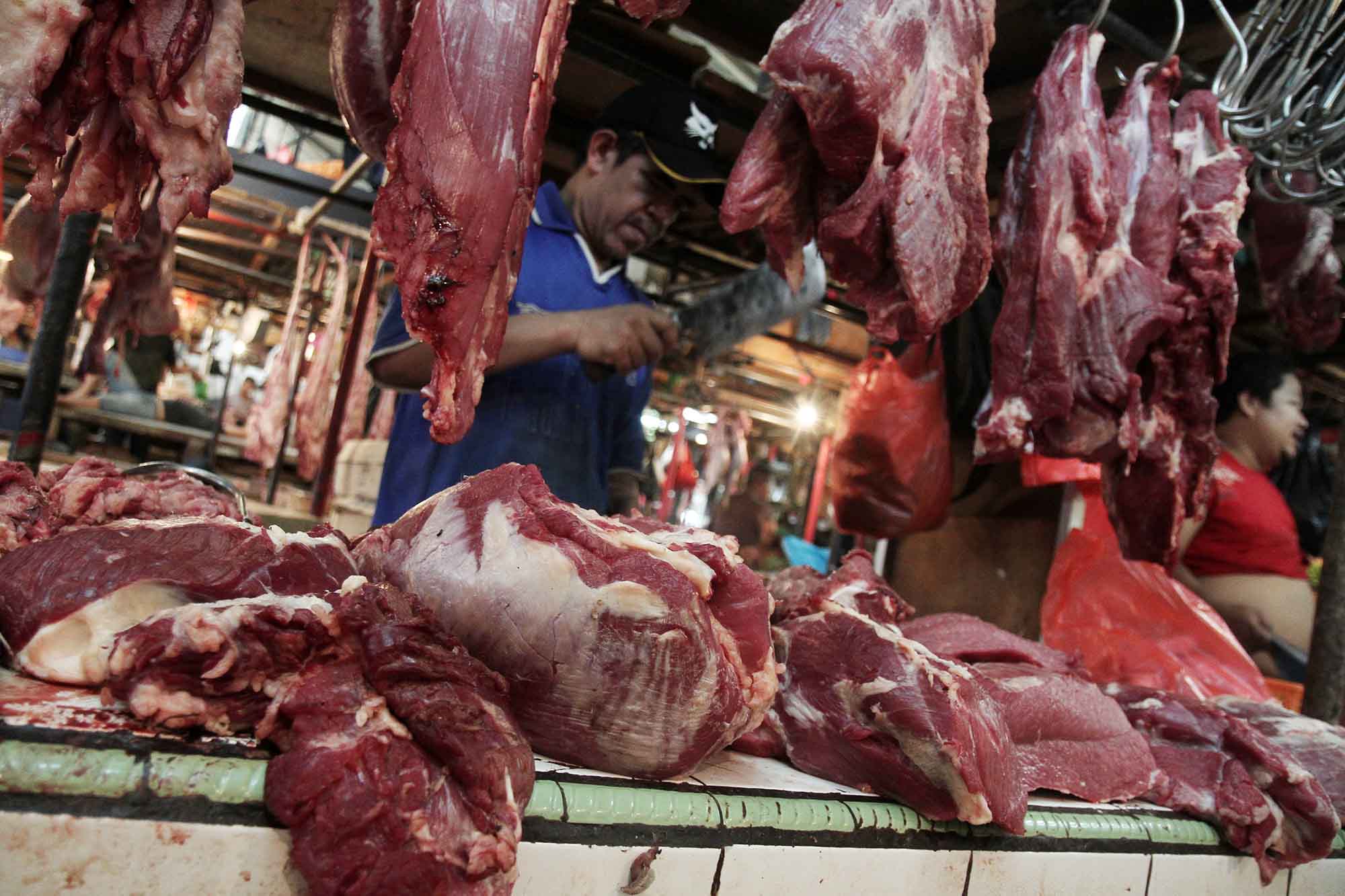 Sejumlah pedagang memotong daging di los daging Pasar Rumput, Jakarta, Selasa (24/02/2026).(Beritanasional.com/Oke Atmaja)