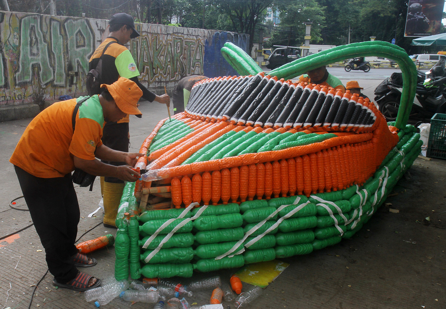 Petugas Unit Penanganan Sampah Badan Air (UPS BA) menyelesaikan pembuatan perahu dari limbah botol plastik di Kwitang, Jakarta, Sabtu (15/7/2024).(BeritaNasional.Com/Oke Atmaja)