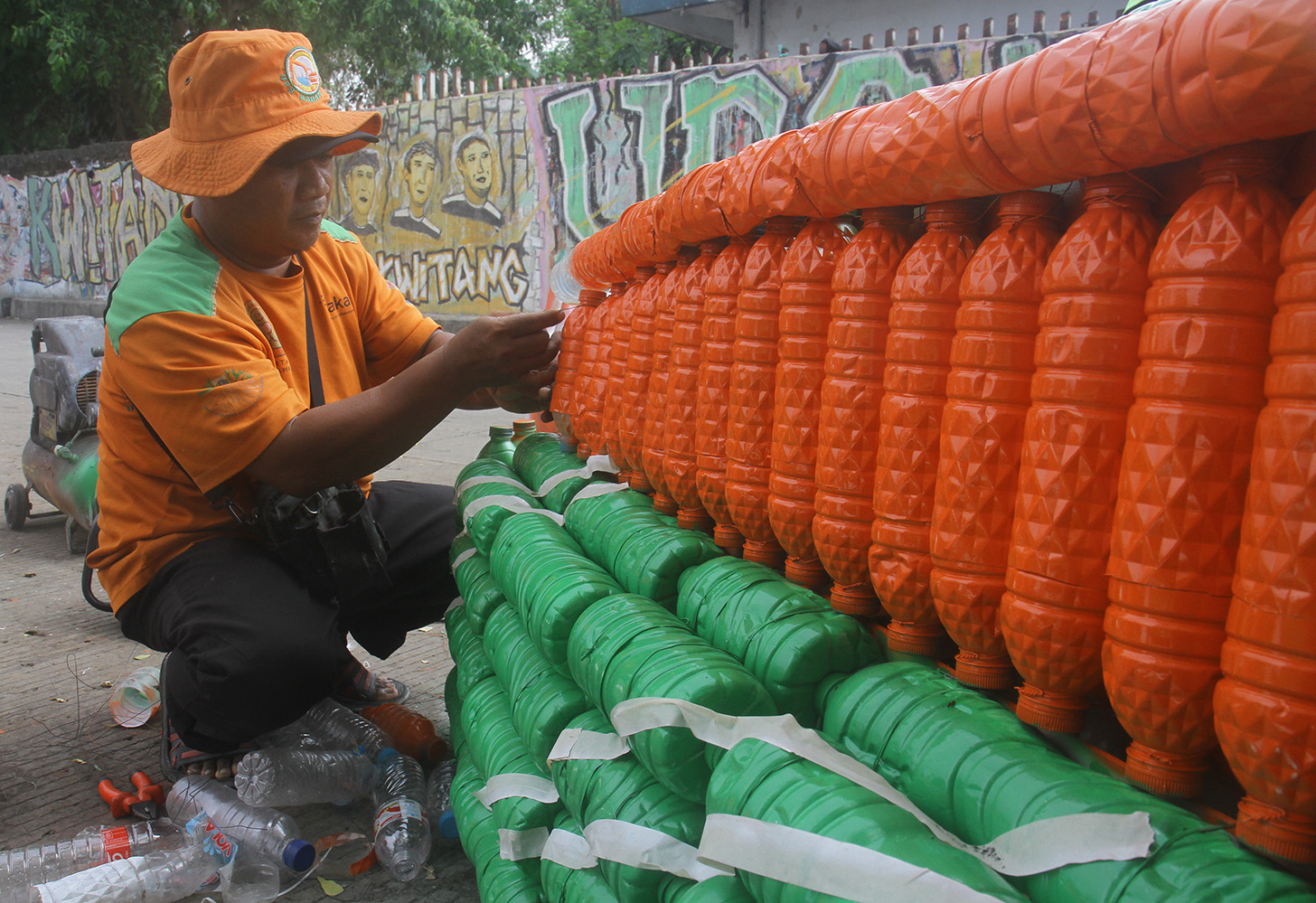 Petugas Unit Penanganan Sampah Badan Air (UPS BA) menyelesaikan pembuatan perahu dari limbah botol plastik di Kwitang, Jakarta, Sabtu (15/7/2024).(BeritaNasional.Com/Oke Atmaja)