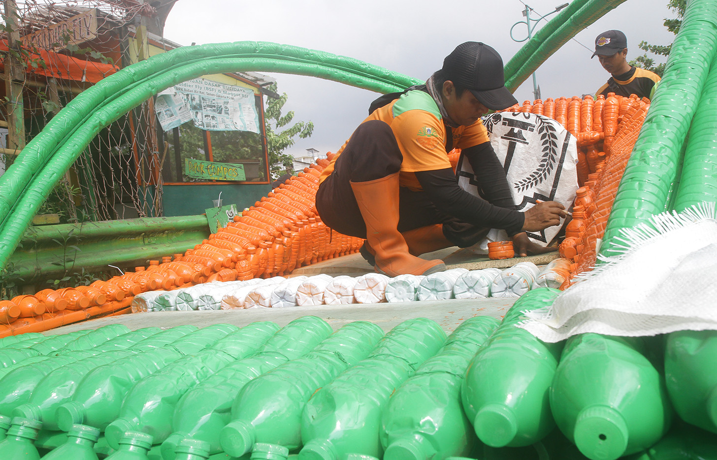 Petugas Unit Penanganan Sampah Badan Air (UPS BA) menyelesaikan pembuatan perahu dari limbah botol plastik di Kwitang, Jakarta, Sabtu (15/7/2024).(BeritaNasional.Com/Oke Atmaja)