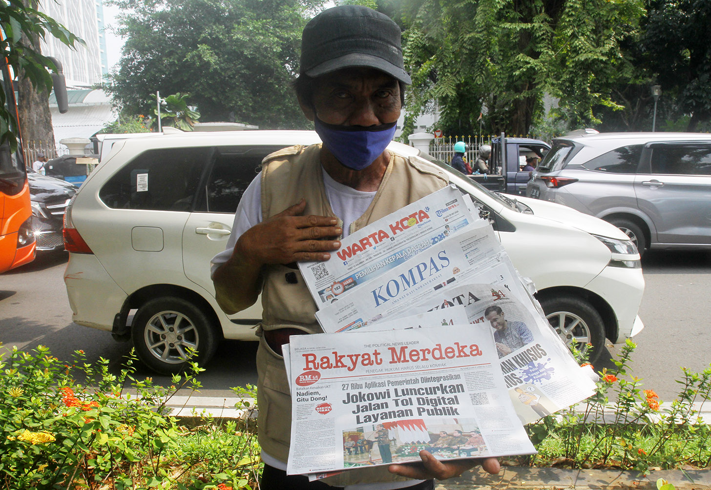 Imron (71) menawarkan koran kepada pembeli di Jalan Pangeran Diponegoro, Jakarta, Senin (3/6/2024).(BeritaNasional.Com/Oke Atmaja)