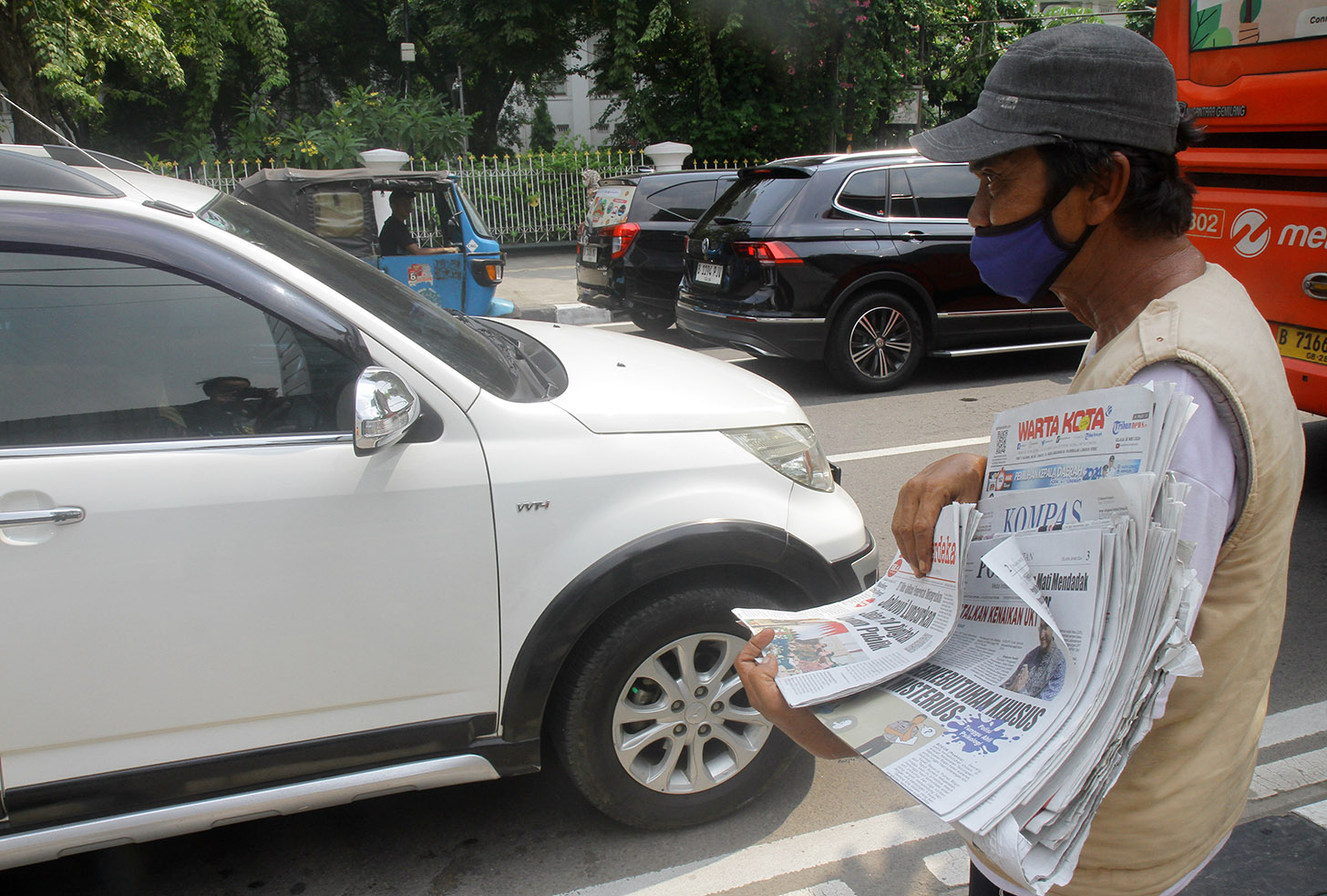 Imron (71) menawarkan koran kepada pembeli di Jalan Pangeran Diponegoro, Jakarta, Senin (3/6/2024).(BeritaNasional.Com/Oke Atmaja)