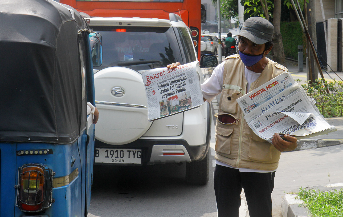 Imron (71) menawarkan koran kepada pembeli di Jalan Pangeran Diponegoro, Jakarta, Senin (3/6/2024).(BeritaNasional.Com/Oke Atmaja)