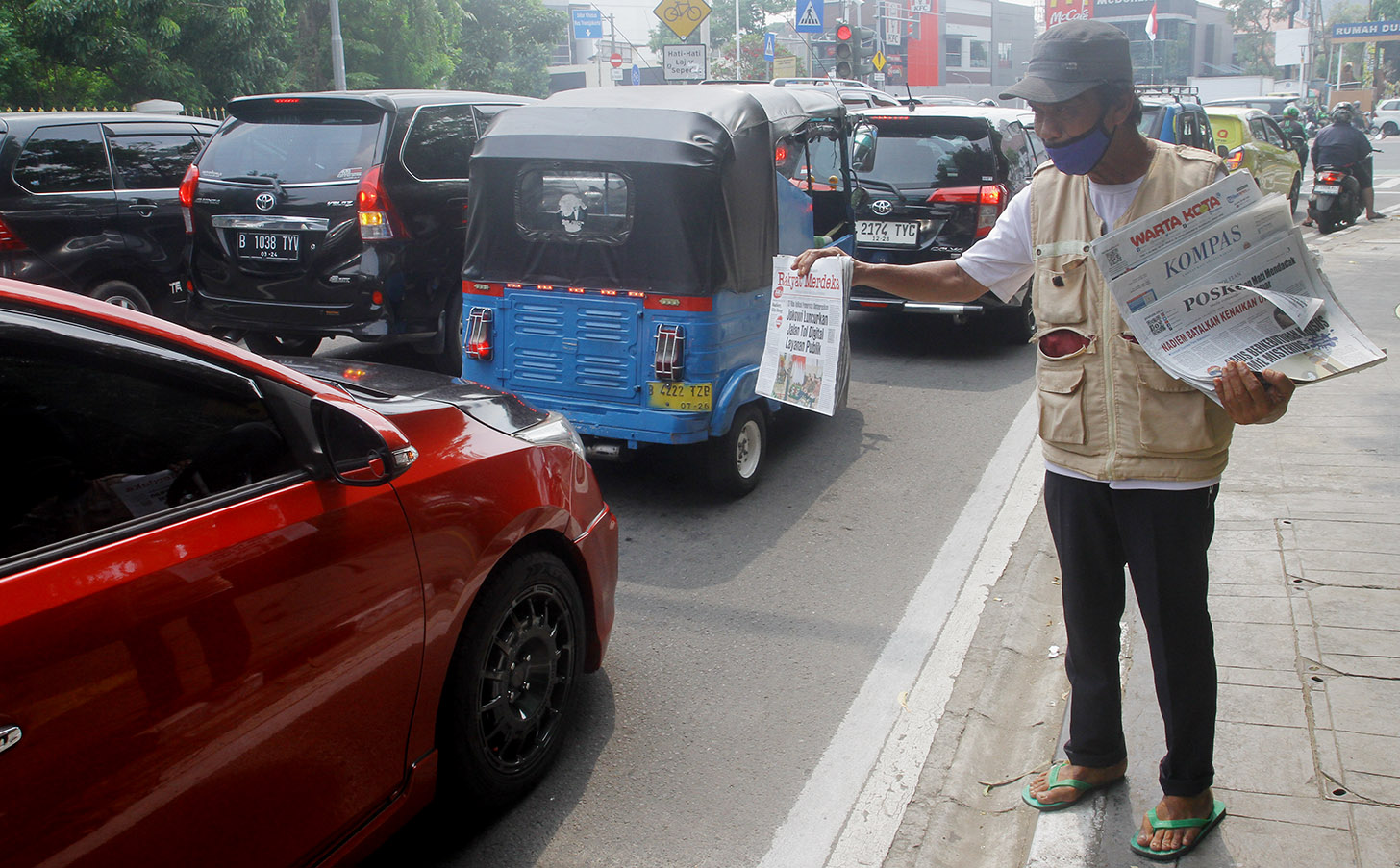 Imron (71) menawarkan koran kepada pembeli di Jalan Pangeran Diponegoro, Jakarta, Senin (3/6/2024).(BeritaNasional.Com/Oke Atmaja)