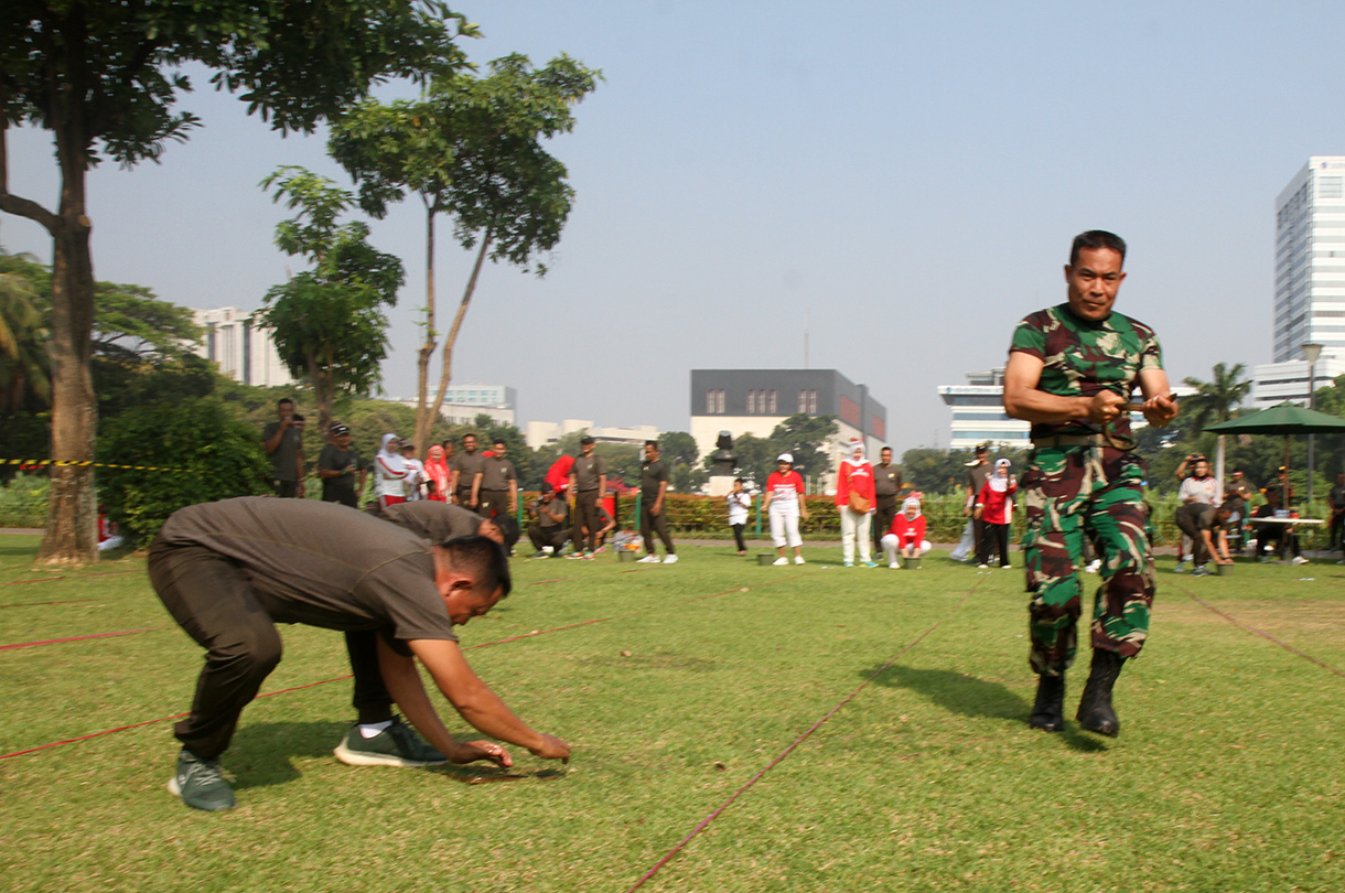 Peserta mengikuti lomba memasukan belut kedalam botol secara estafet dalam rangka memperingati HUT RI ke-79, di Silang Monas, Jakarta, Kamis (15/8/2024).  (BeritaNasional.com/ Oke Atmaja)