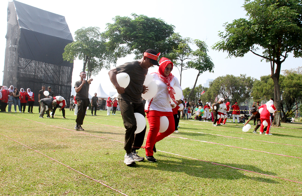 Peserta mengikuti lomba memasukan belut kedalam botol secara estafet dalam rangka memperingati HUT RI ke-79, di Silang Monas, Jakarta, Kamis (15/8/2024).  (BeritaNasional.com/ Oke Atmaja)