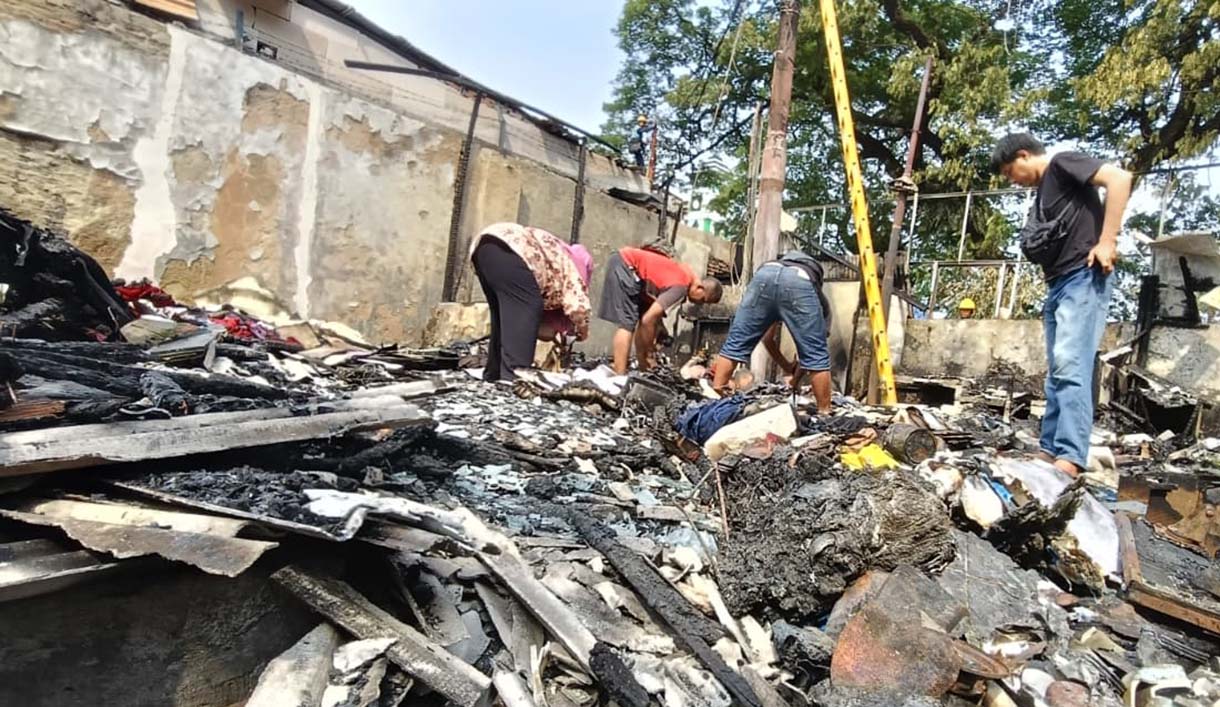 Pedagang mencari barang yang tersisa di kios yang terbakar di kawasan Kalibata, Jakarta, Jumat (12/12/2025).  (Beritanasional.com/Oke Atmaja)