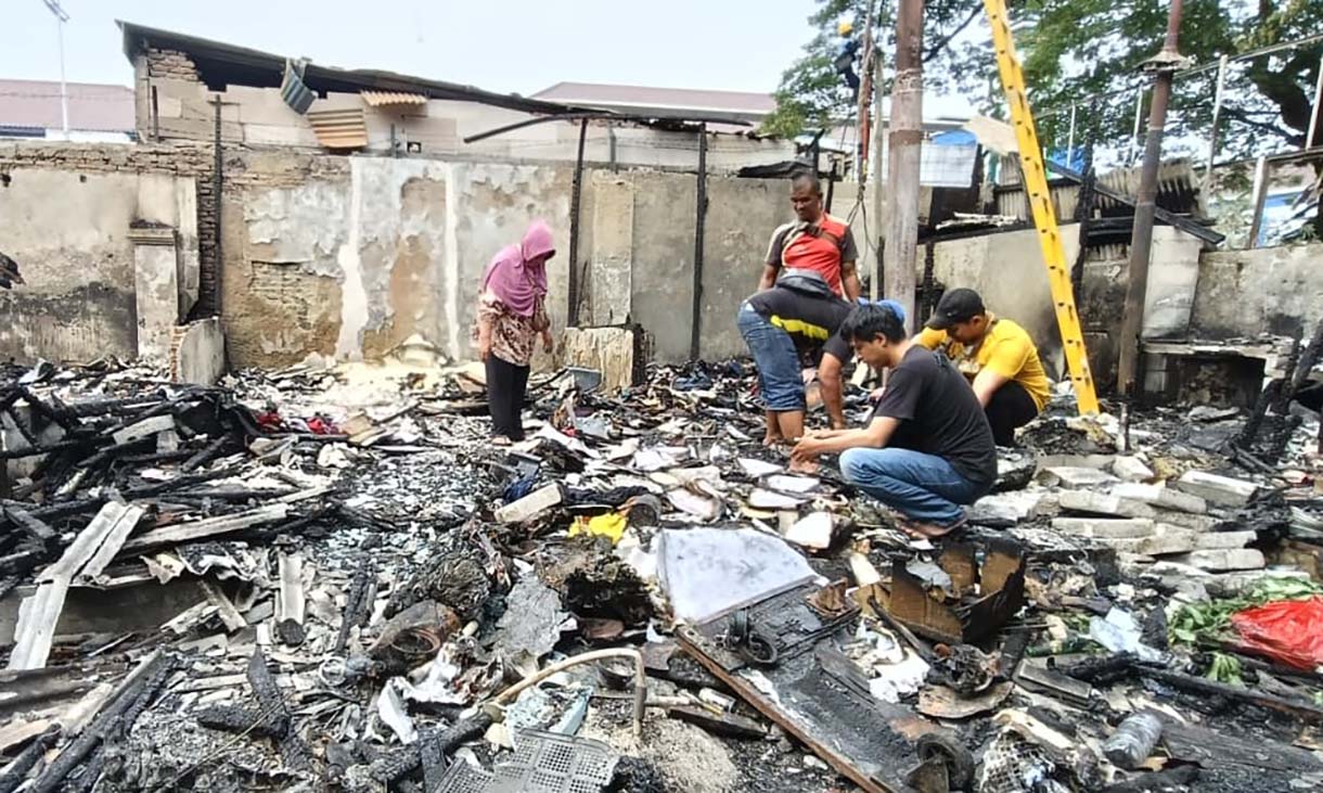 Pedagang mencari barang yang tersisa di kios yang terbakar di kawasan Kalibata, Jakarta, Jumat (12/12/2025).  (Beritanasional.com/Oke Atmaja)