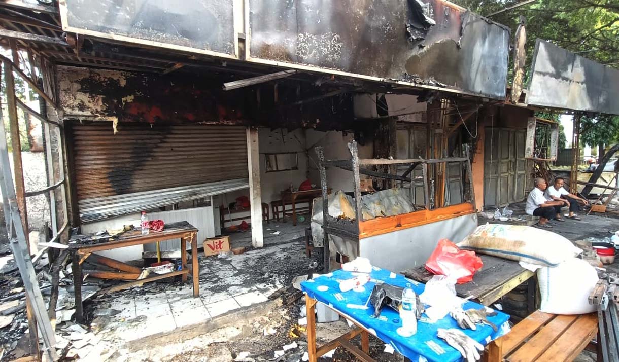 Pedagang mencari barang yang tersisa di kios yang terbakar di kawasan Kalibata, Jakarta, Jumat (12/12/2025).  (Beritanasional.com/Oke Atmaja)