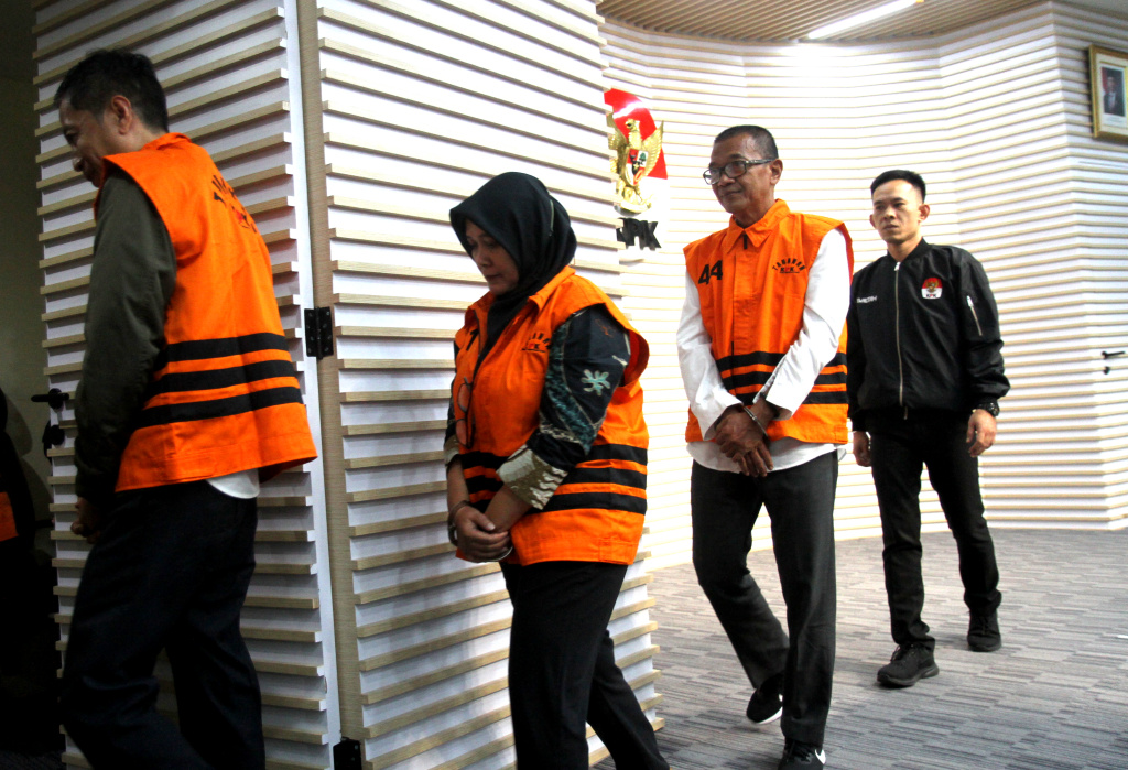 KPK Tahan Empat Tersangka Korupsi di Kemenaker Empat tersangka dugaan pemerasan dalam pengurusan Rencana Penggunaan Tenaga Kerja Asing (RPTKA) di lingkungan Kementerian Ketenagakerjaan, mantan Direktur Pengendalian Penggunaan TKA Kemenaker Wisnu Pramono (kiri), mantan Dirjen Binapenta dan PKK Kemenaker Haryanto (kedua kiri), mantan Direktur PPTKA Kemenaker Devi Anggraeni (kedua kanan), dan mantan Direktur Jenderal Pembinaan Penempatan Tenaga Kerja dan Perluasan Kesempatan Kerja Kemenaker Suhartono (kanan) berdiri dalam konferensi pers penahanan mereka di Gedung Merah Putih KPK, Jakarta, Kamis (17/7/2025). (Beritanasional.com/ Oke Atmaja)