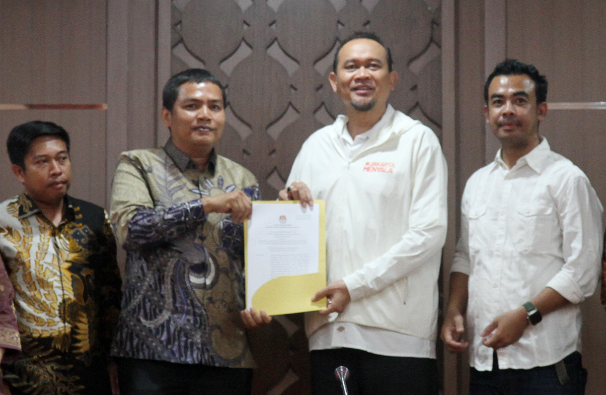 Ketua KPU DKI Jakarta Wahyu Dinata (kiri) memberikan surat penetapan pasangan calon peserta Pilgub DKI Jakarta kepada Ketua tim pemenangan Calon Gubernur Pramono Anung- Calon Wakil Gubernur Rano Karno, Lies Hartono alis Cak Lontong (kanan) di Salemba, Jakarta Pusat, Minggu (22/9/2024).  (BeritaNasional.com/ Oke Atmaja)